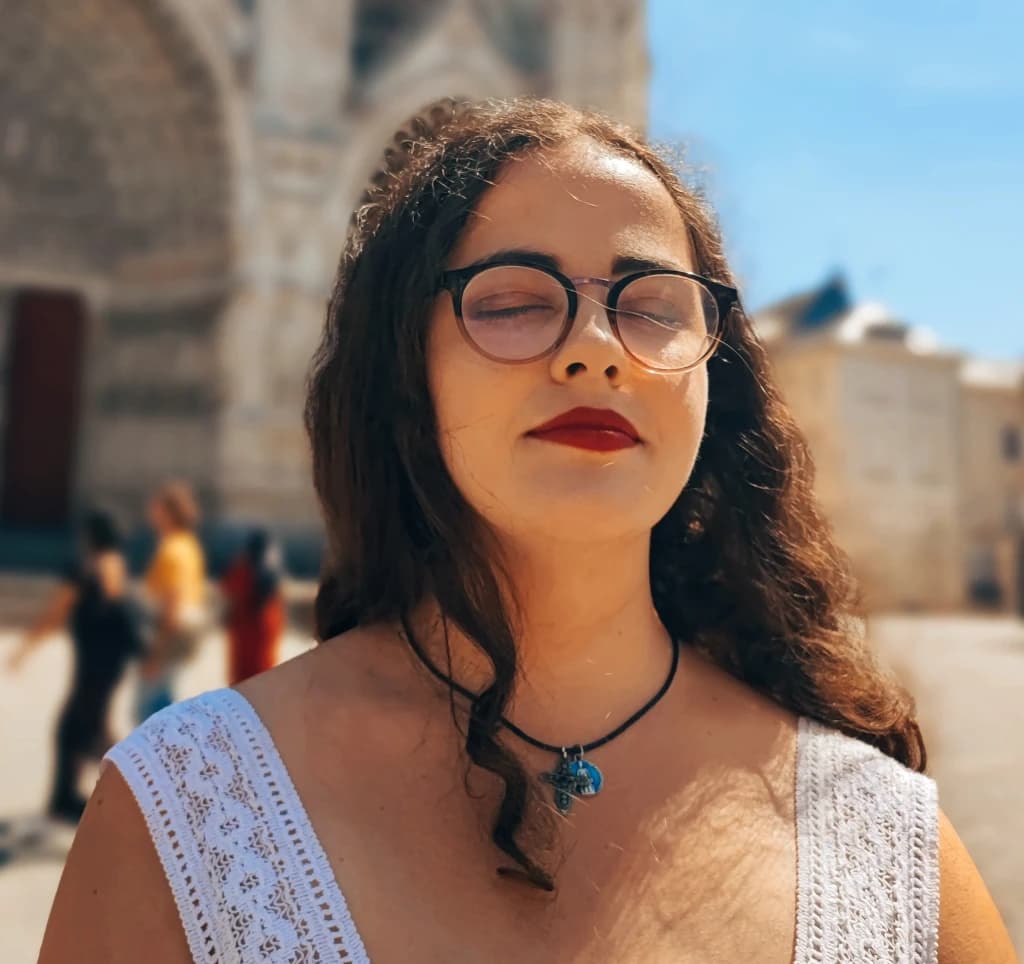 Portrait de Manon Segur en robe blanche devant la cathédrale d’Amiens
